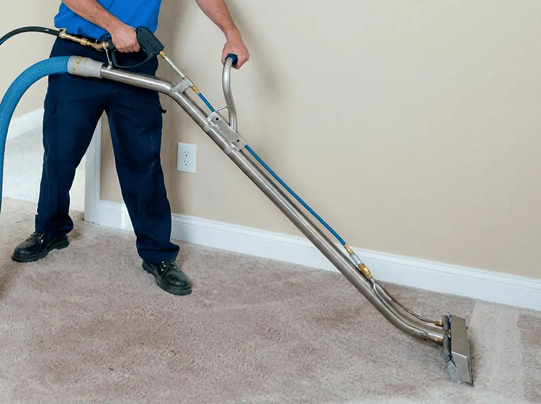 Professional operating a liquid removal machine on a carpeted floor in Houston, TX