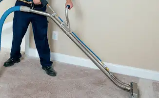 Professional operating a liquid removal machine on a carpeted floor in Houston, TX